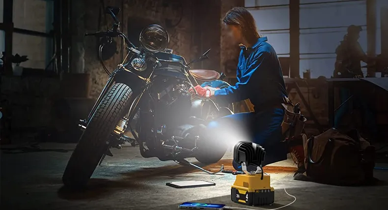 Rechargeable portable LED work light standing on a job-site surface without a power cable