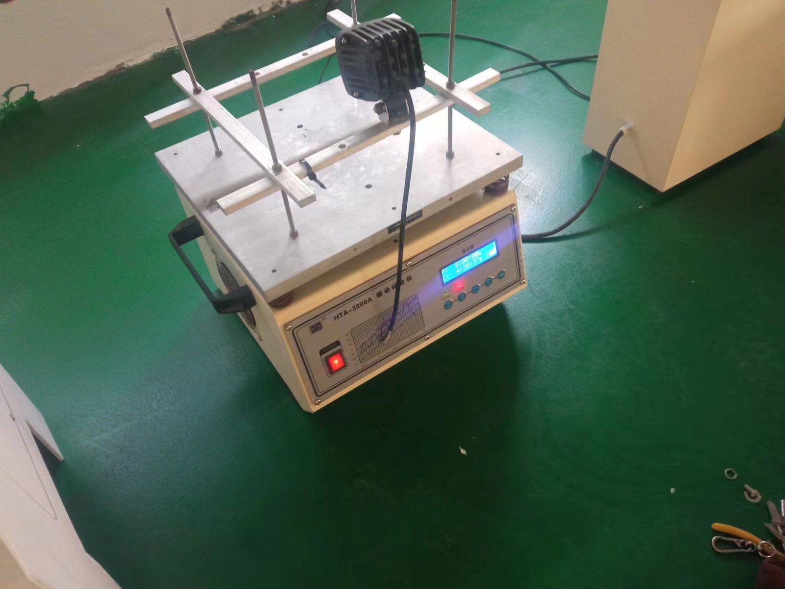 LED warning light mounted on a vibration and shock test table to verify solder joint durability